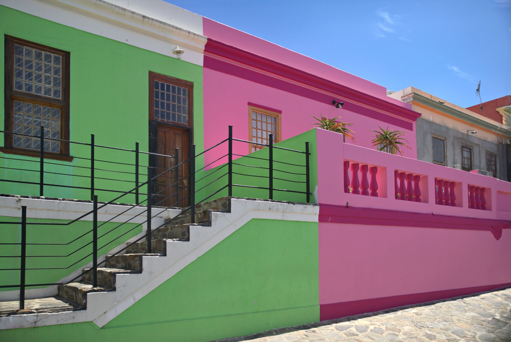 Das Bo-Kaap in Kapstadt ist bekannt für seine bunten Häuser, Kopfsteinpflasterstraßen und die Cape-Malay-Kultur. Ursprünglich zwischen 1760 und 1840 von muslimischen und befreiten Sklaven aus Südostasien erbaut, bemalten die Bewohner nach 1834 ihre Häuser als Zeichen der Freiheit. Heute ist das Viertel ein geschütztes historisches Gebiet.